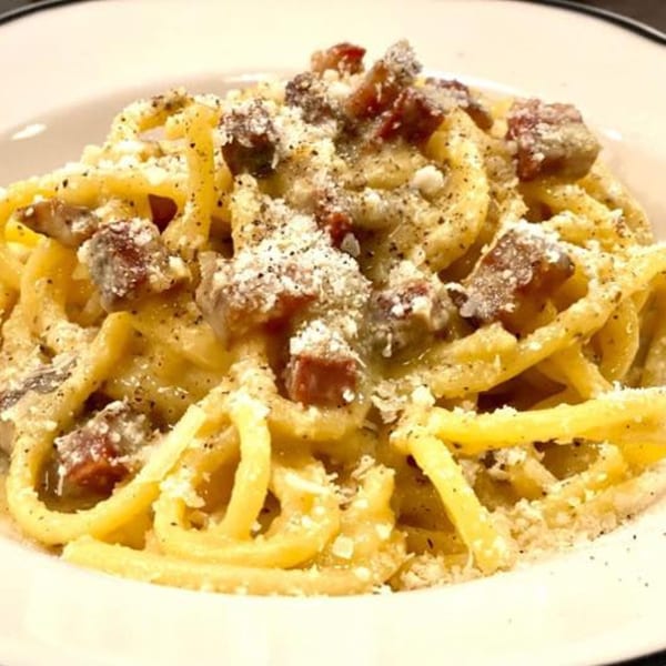 Close-up of Capp's Pizzeria & Trattoria's carbonara pasta with bacon, cheese, and black pepper.